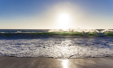 Wave in the sunlight at the surf spot of Nazaré, Portugal