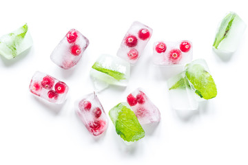 Obraz na płótnie Canvas mint and red berries in ice cubes white background top view