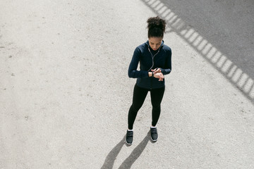 Top view shot of young woman checking activity tracker after exercise 