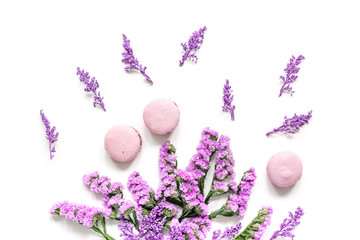 Trendy woman pattern with flowers and macaroons on plate top view
