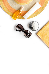 Towel, sun lotion, glasses on white background top view space for text