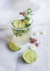 fresh homemade drink with flowers and lime on kitchen background