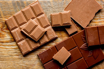 black and milk chocolate bars with mint dark wooden table background top view
