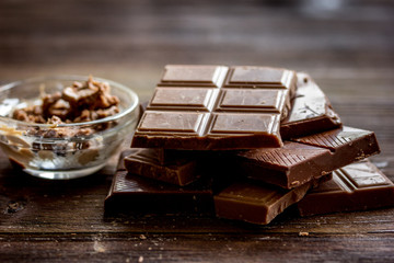 chopped chocolate pieces for dessert dark wooden desk background