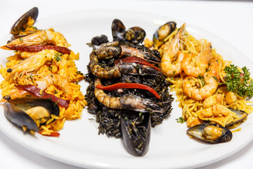 paella, black rice and fideua on same plate. Typical spanish food
