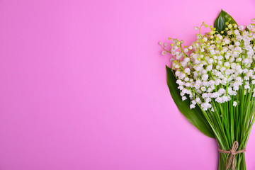 Bouquet of white lilies of the valley on a pink surface