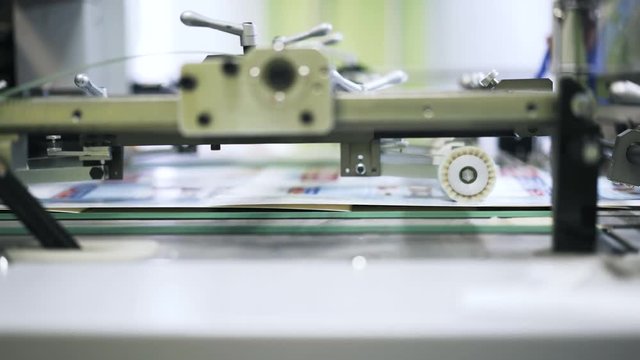 Close up of a printing plant machine with a rotation mechanism working. Locked down slow motion close up shot