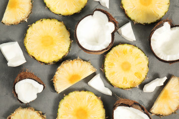 Composition of fresh coconut and pineapple slices on gray background
