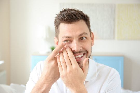 Young Man Putting Contact Lenses At Home