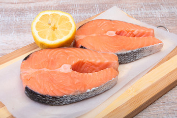 fresh raw salmon with spices and lemon on wooden cutting board. ready for cookin