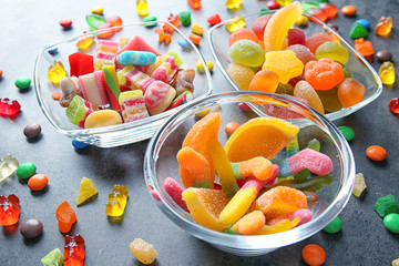 Composition with tasty colorful candies on grey background, closeup