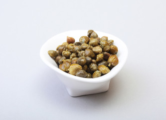 bowl with fresh capers isolated on white background.