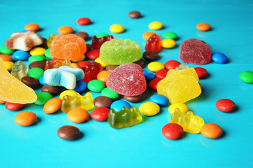 Fototapeta na wymiar Composition with tasty colorful candies on wooden background, closeup