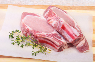 Raw pork chops, spices and rosemary on cutting board. Ready for cooking.