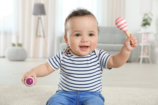 Cute little baby with rattles at home