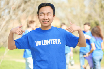 Young Asian volunteer with team outdoors