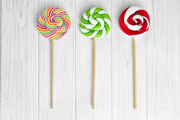 Multicolored lollipops on wooden background