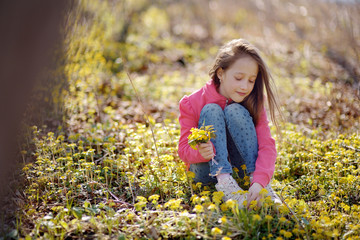 the happy girl collects flowers in the spring wood