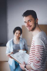 Obraz premium Young couple sitting on the floor of their new apartment