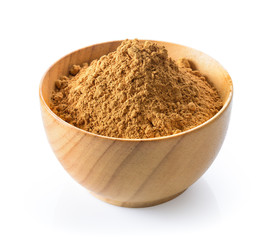 Cinnamon powder in wood spoon on white background