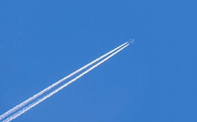 Diagonal trace of plane flying in blue sky