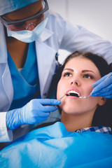 Fototapeta premium Woman dentist working at her patients teeth