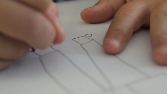 Primary school child drawing a persons legs