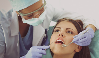 Woman dentist working at her patient&amp;amp;#39;s teeth