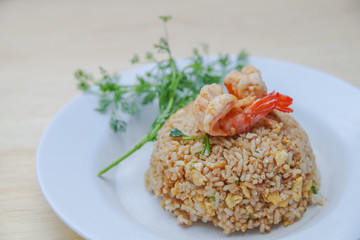 Stir fried rice in white plate on wooden table, close up fried rice, Thai food