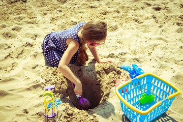 Little girl kid child with toy having fun on beach
