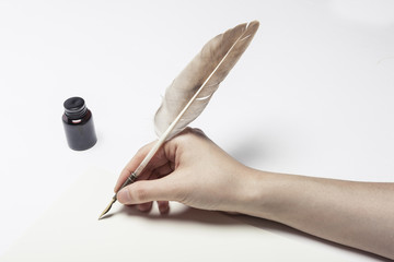 woman hand hold a fountain pen with ink on the white table.