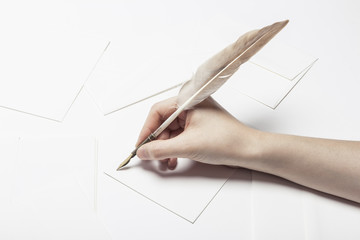 woman hand hold a fountain pen with letter on the white table.