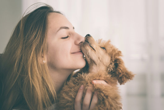 Young girl kissing her good friend dog . Positive human emotions.