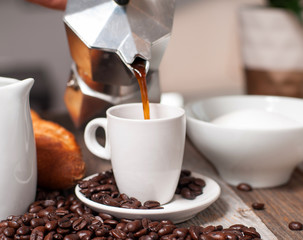 Cup of coffee and coffee pot on wood table