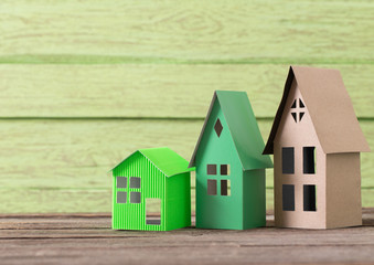 paper house on green wooden background