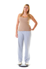 Happy woman wearing tracksuit standing on weighing machine