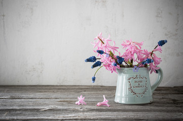 spring flowers in blue jug on grunge background