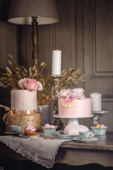 Luxury wedding table with a beautiful pink cake decorated with mastic and rose gold in antique classic interior