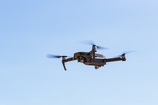 Unmanned aerial vehical with video camera hovers in the air. This is DJI Mavic Pro model.