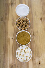 Different kind of white and brown sugar on old brown table