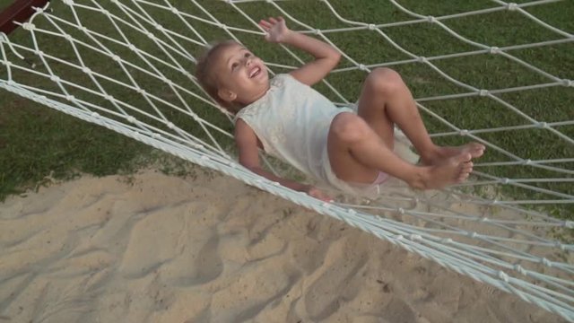 Happy little girl swinging in hammock slow motion stock footage video