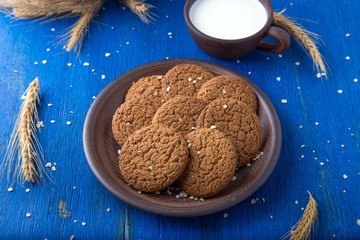 Oatmeal cookies in brown plate on blue background. Rustic style. Top view