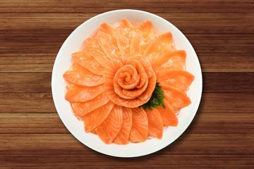 Top view of salmon sashimi serve on flower shape in white ice bowl boat on wood table background, Japanese style.