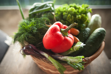 Fresh vegetables in a basket. Courgettes, cucumbers, carrots, onions, dill, parsley  