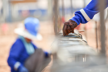 Construction workers hands using steel wire construction and pincers to secure rebar before concrete is poured over it in construction sit mega construction project,Construction concept