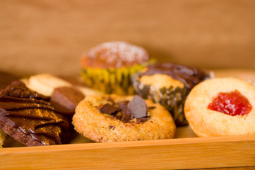 Freshly baked vanilla and chocolate chip cookies on wooden tray