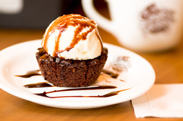 Delicious icecream on top of a brownie with a chocolate sauce in the plate