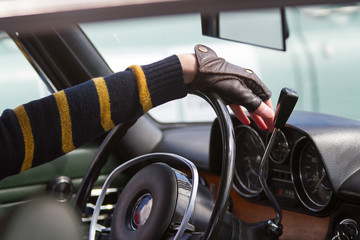 driver keeps hands on steering wheel of his vintage car