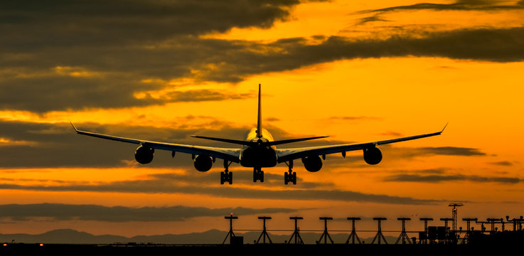 Airplane landing at an amazing sunset