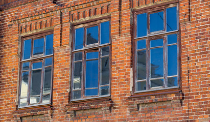 Old wooden window in the wall of red brick